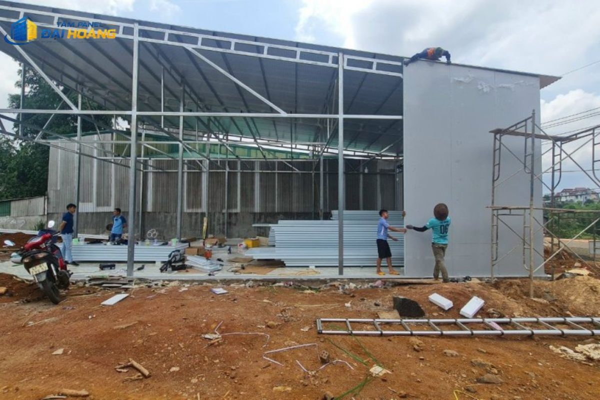 Thợ đang thi công lắp trần bằng tấm Panel RockWool 75mm dưới mái tôn giúp giảm nhiệt và tiết kiệm điện điều hòa